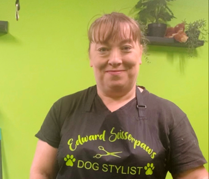 Your dog stylist in the lime green salon, wearing her black Edward Scissorpaws Dog Stylist apron